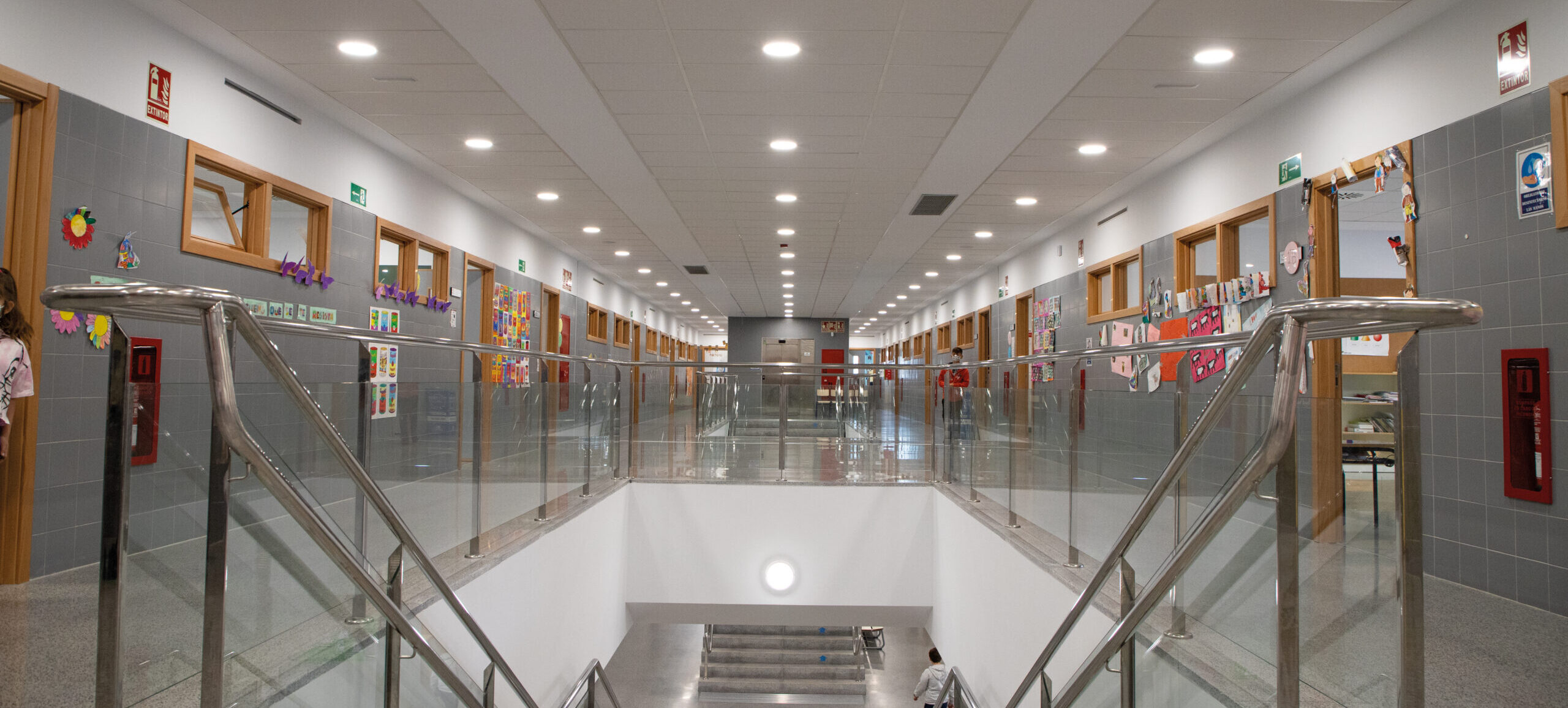 Pasillo de centro educativo iluminado con tecnología LED por Prilux